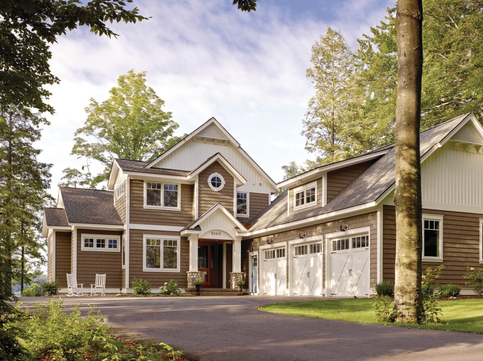 A beautiful home with a brown exterior containing vinyl siding and vinyl windows on a large piece of
